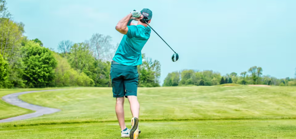 Luxury golf safari experience in Kenya - Professional golfer teeing off on exclusive championship course surrounded by African wilderness